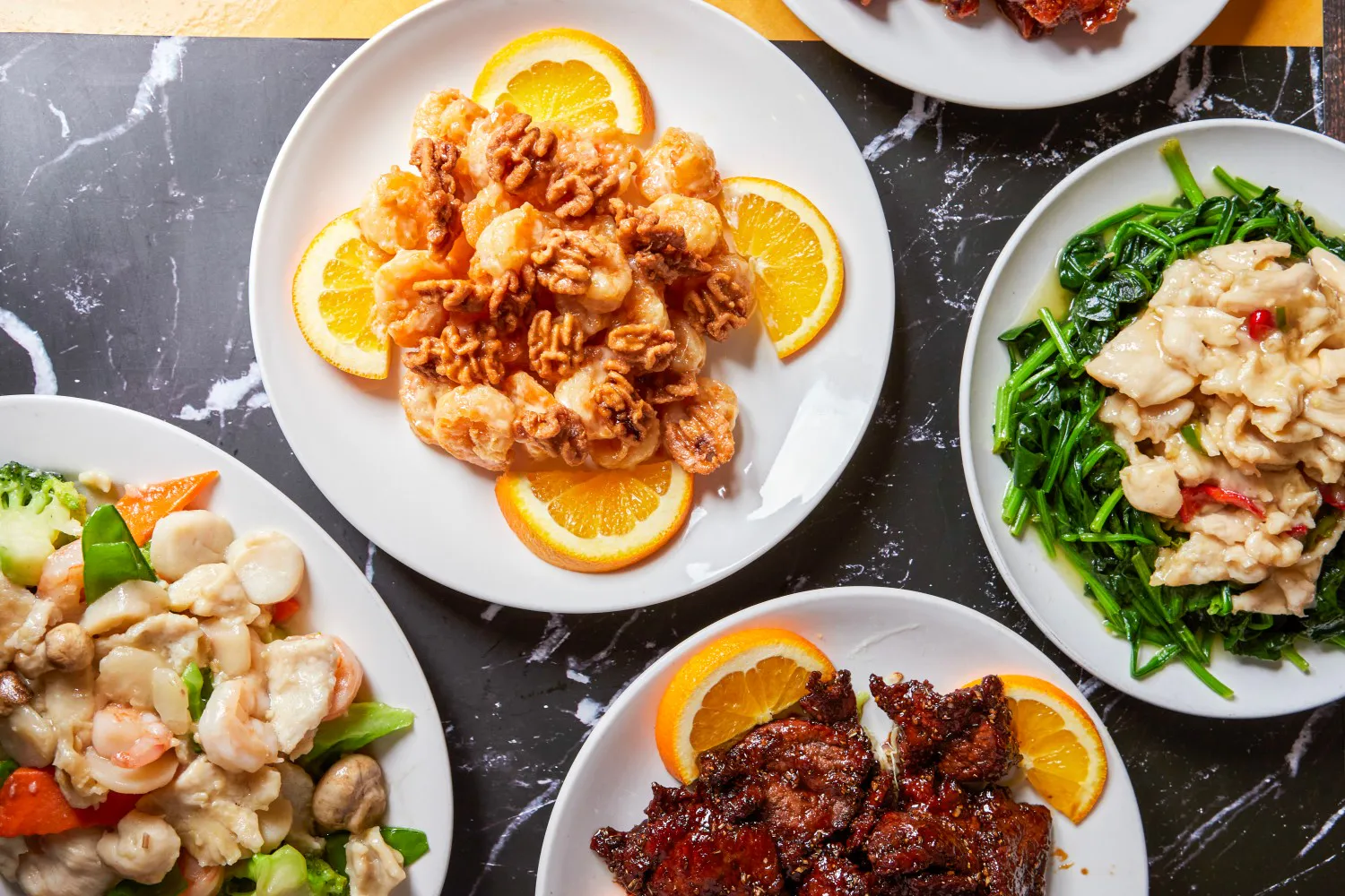 Assorted Chinese dishes including walnut shrimp, stir-fried veggies, and meat at Super Wok Chinese Restaurant in Tarzana